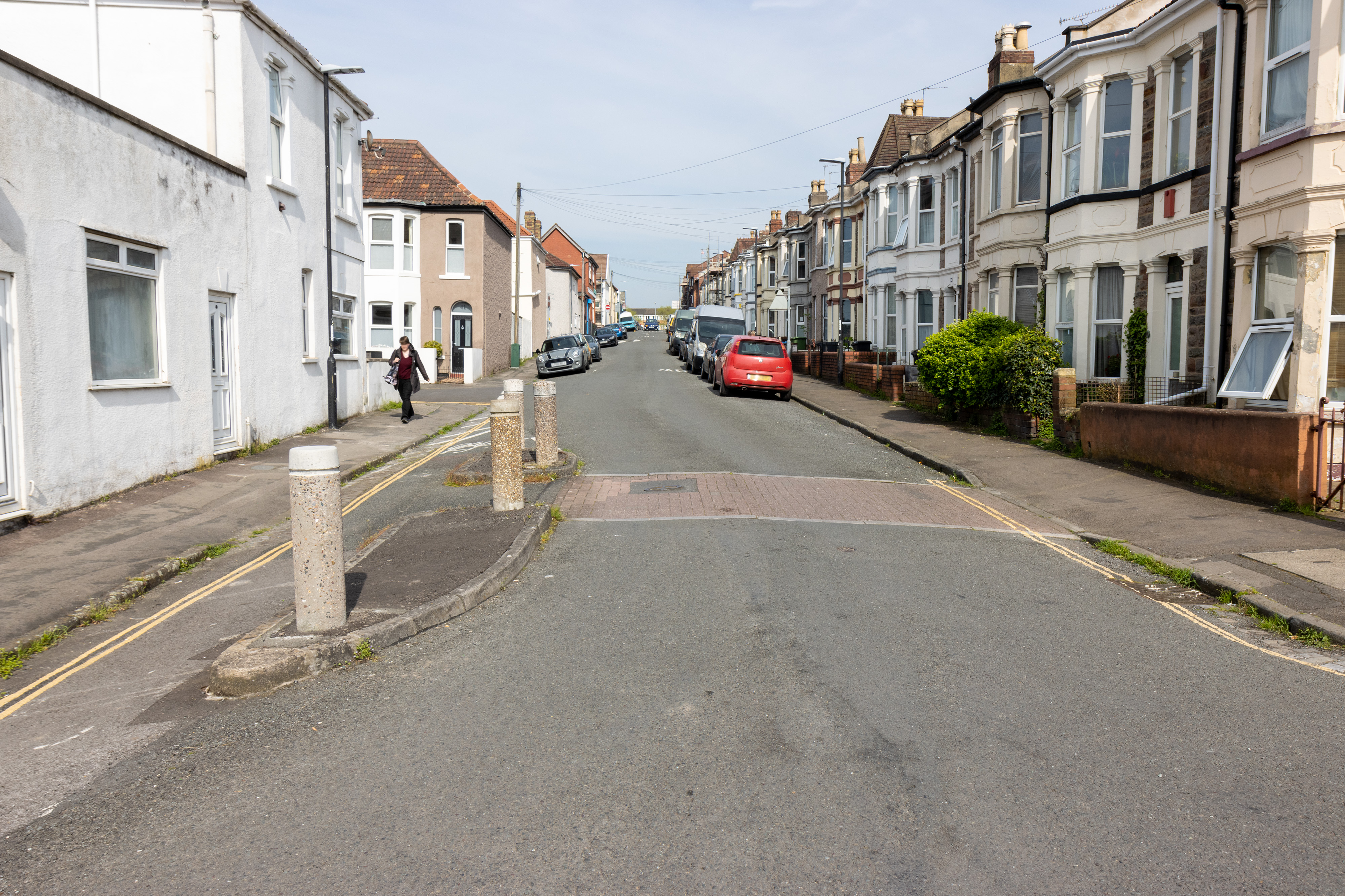 Cars parked on one side of the street, with a cycle bypass on the other.