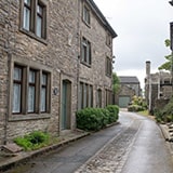 Larger village with some terraced stone houses along a small stone lane.