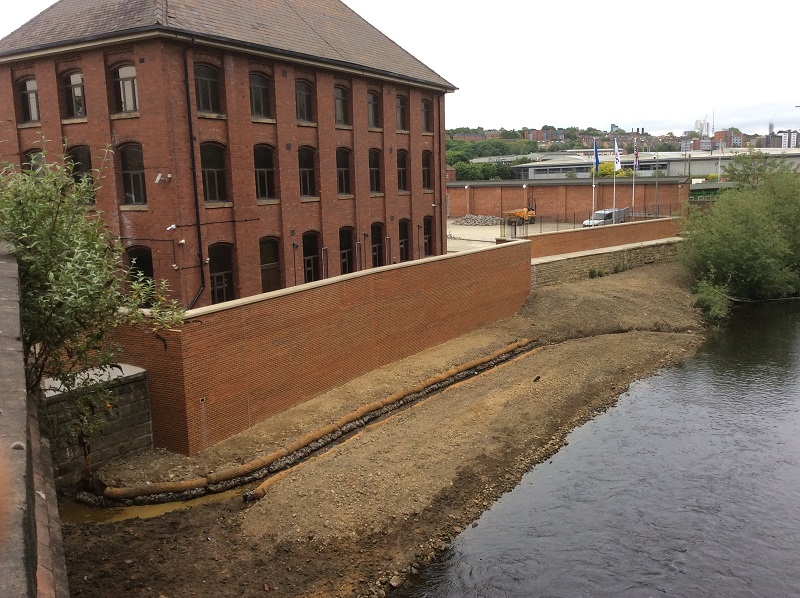 a completed flood wall by the river Aire