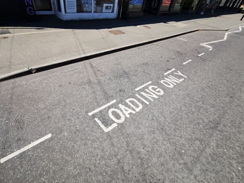 markings on a road which say "Loading only"