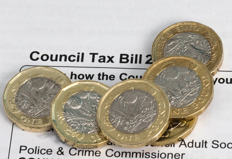 Coins on top of a council tax bill