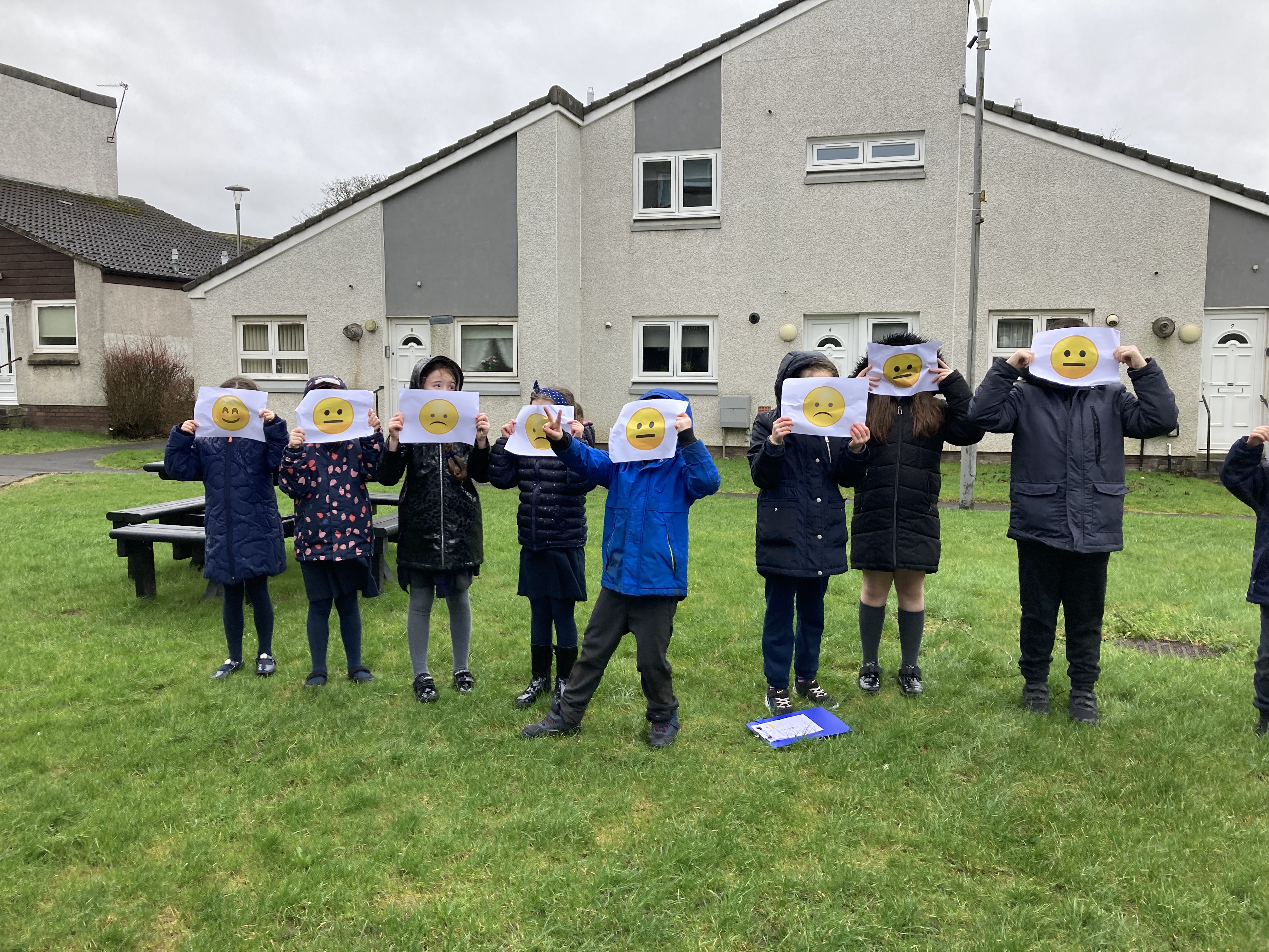 Wallace Primary School pupils in Stoddard Square with emoji faces to tell us how they feel here