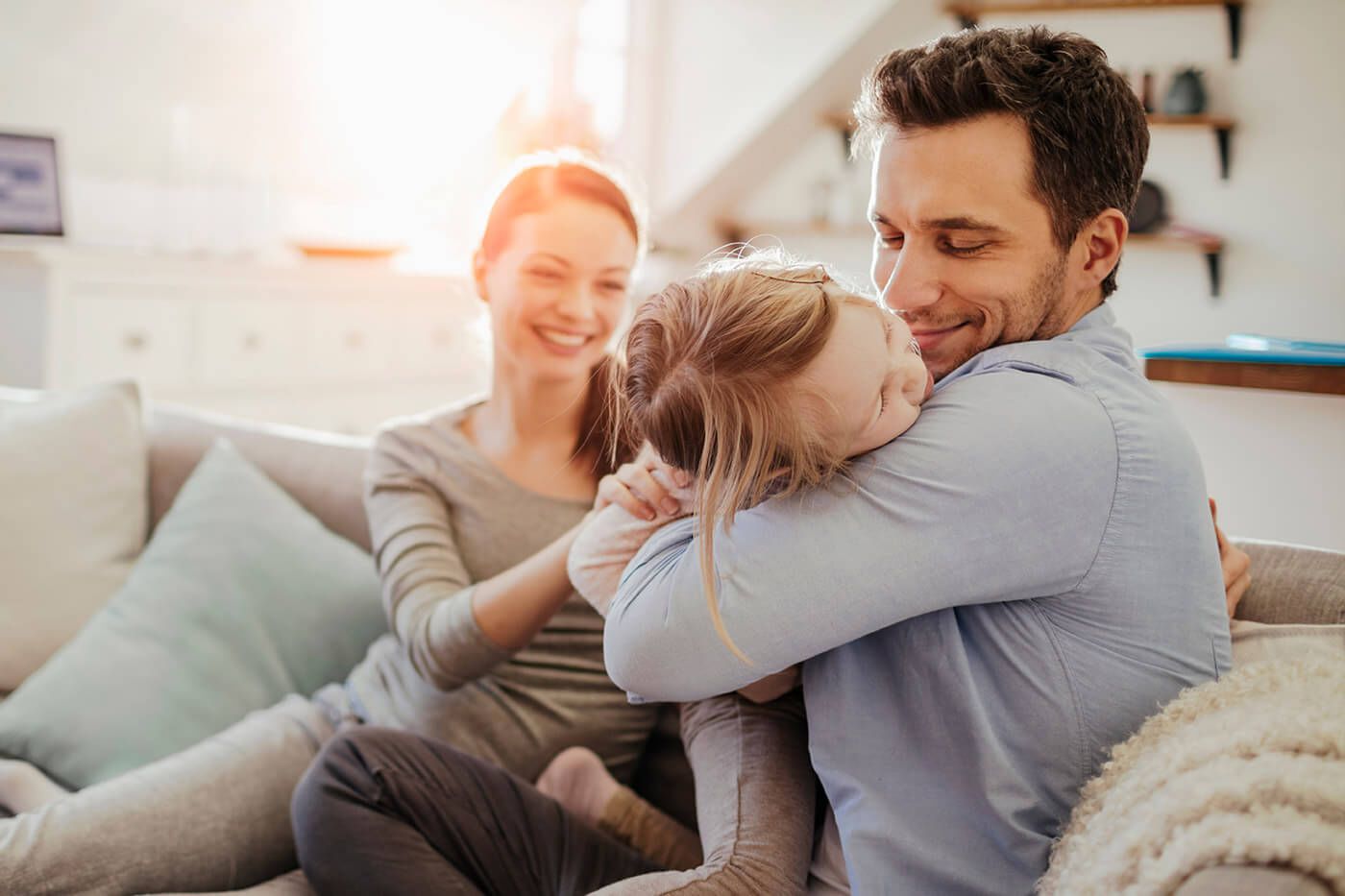A man hugging his daughter with his wife sitting next to him