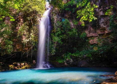 seguro viagem costa rica cachoeira azul turquesa no meio da selva