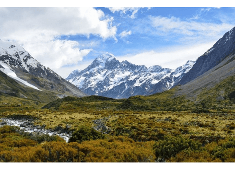 seguro viagem oceania - campos verdes com montanhas nevadas ao fundo