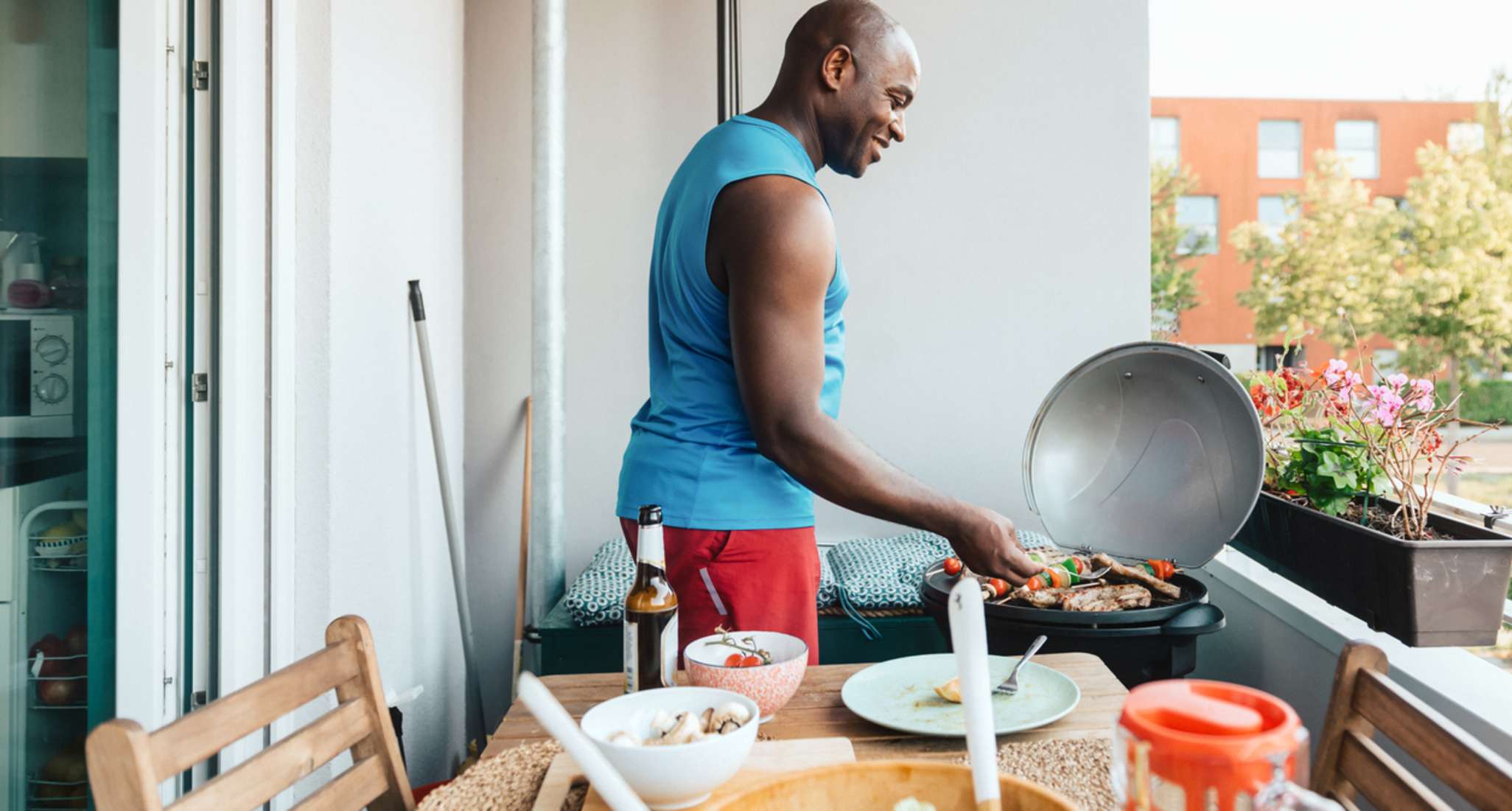 A man is barbecuing on his balcony. Problems can often arise if the neighbourhood is covered in a cloud of smoke.