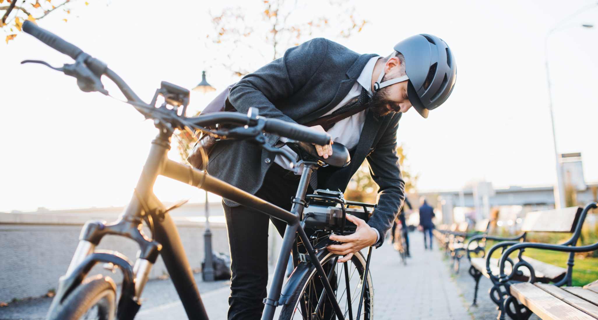 Un homme avec un casque ferme un vélo électrique