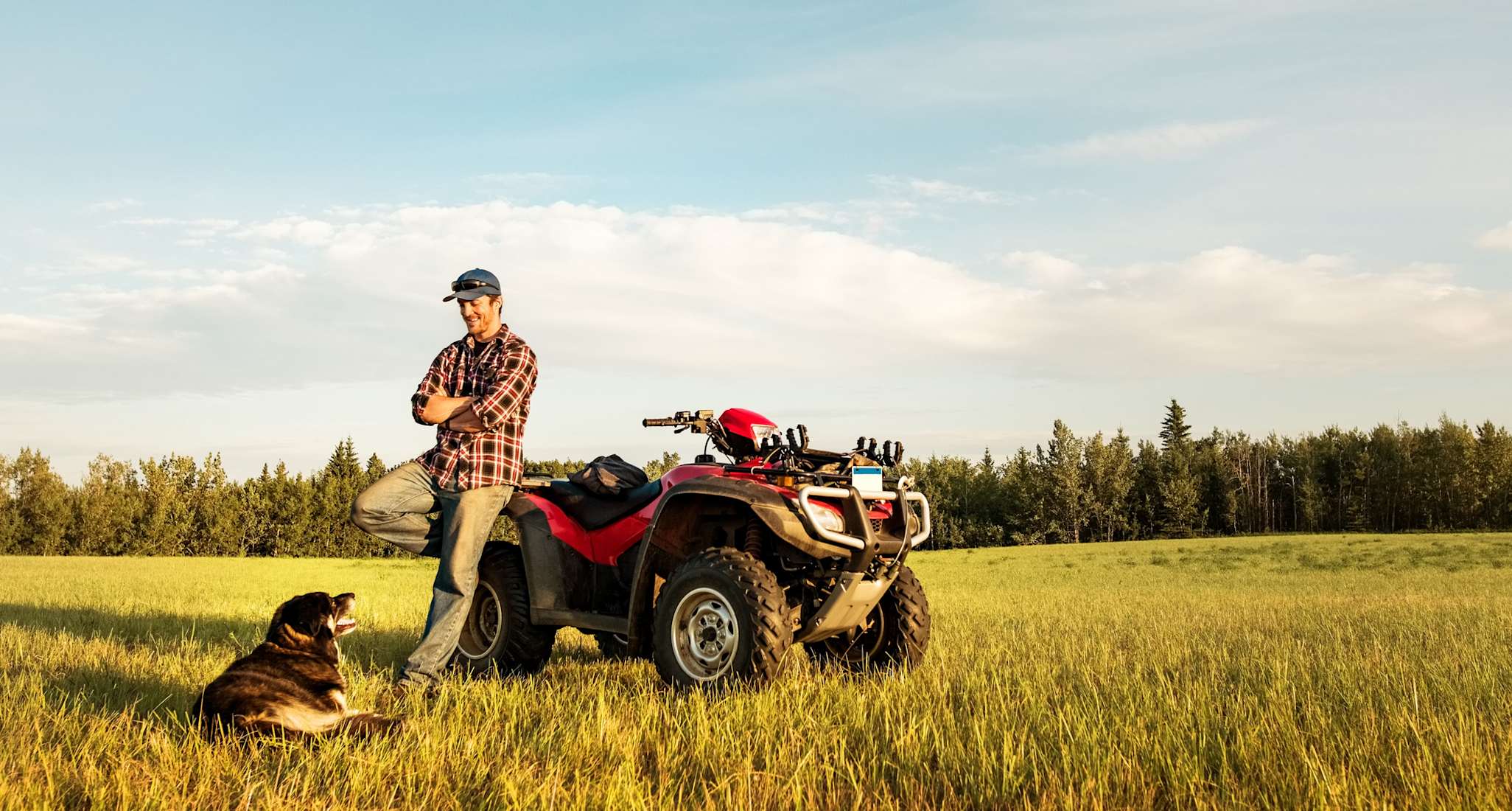 A quad that is being driven on a steep field.