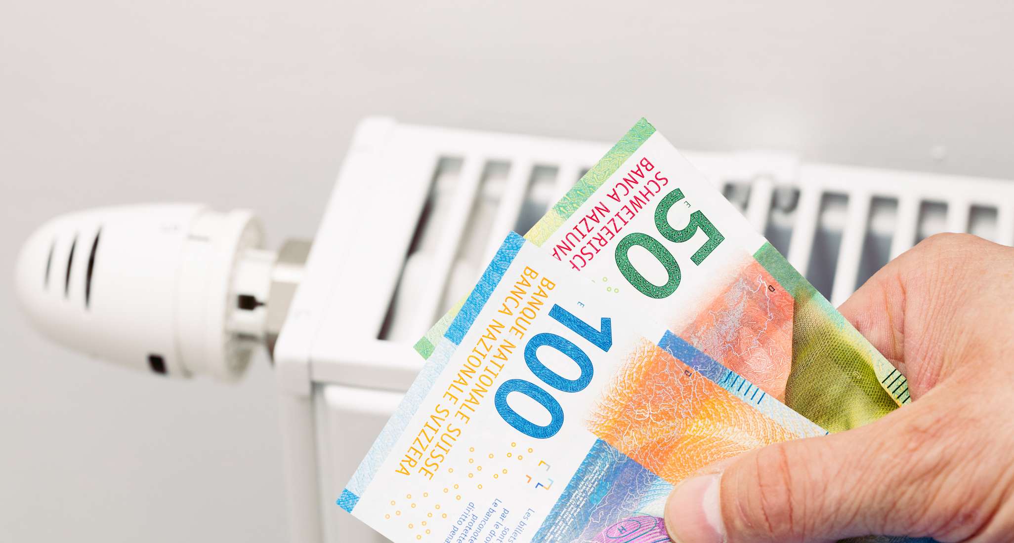 Schweizer Banknoten mit Heizung im Hintergrund