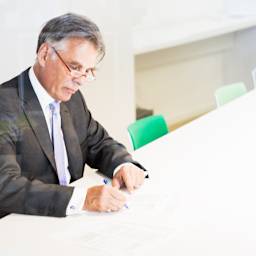 Un notaire signe un contrat de vente par acte authentique.