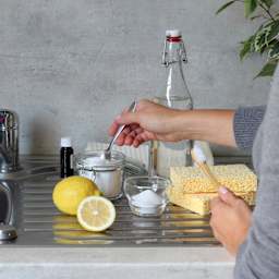 Eine Person bereitet zum Schimmel entfernen Hausmittel vor.