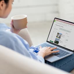 Eine Frau sucht auf ihrem Laptop nach einer neuen Wohnung.