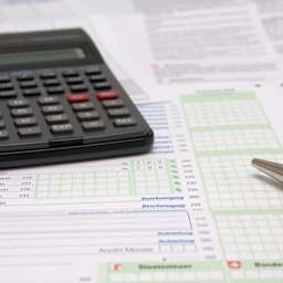 A calculator and a pen on tax declaration forms.