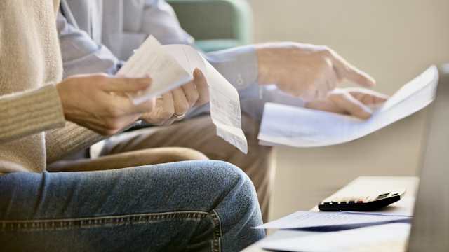 Paar informiert sich mit Dokumenten über Kreditaufstockung