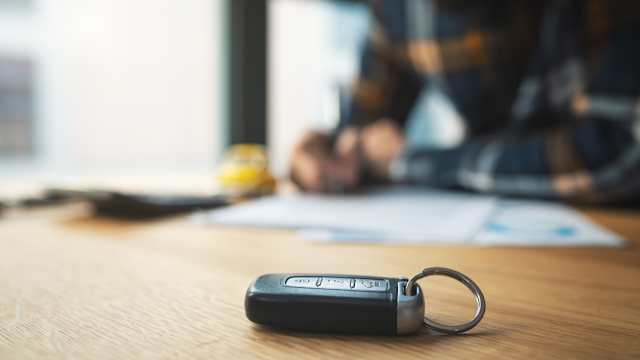 Un homme signe un contrat d’achat et un document d’assurance pour sa voiture.