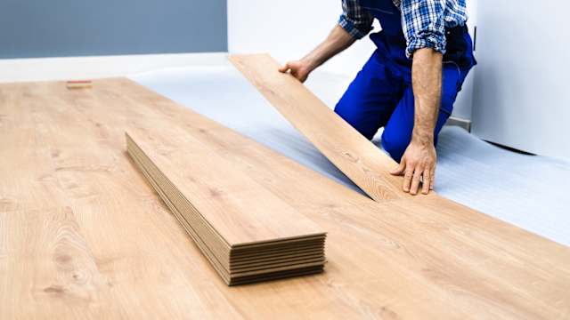 Tradesperson installing new flooring in a home