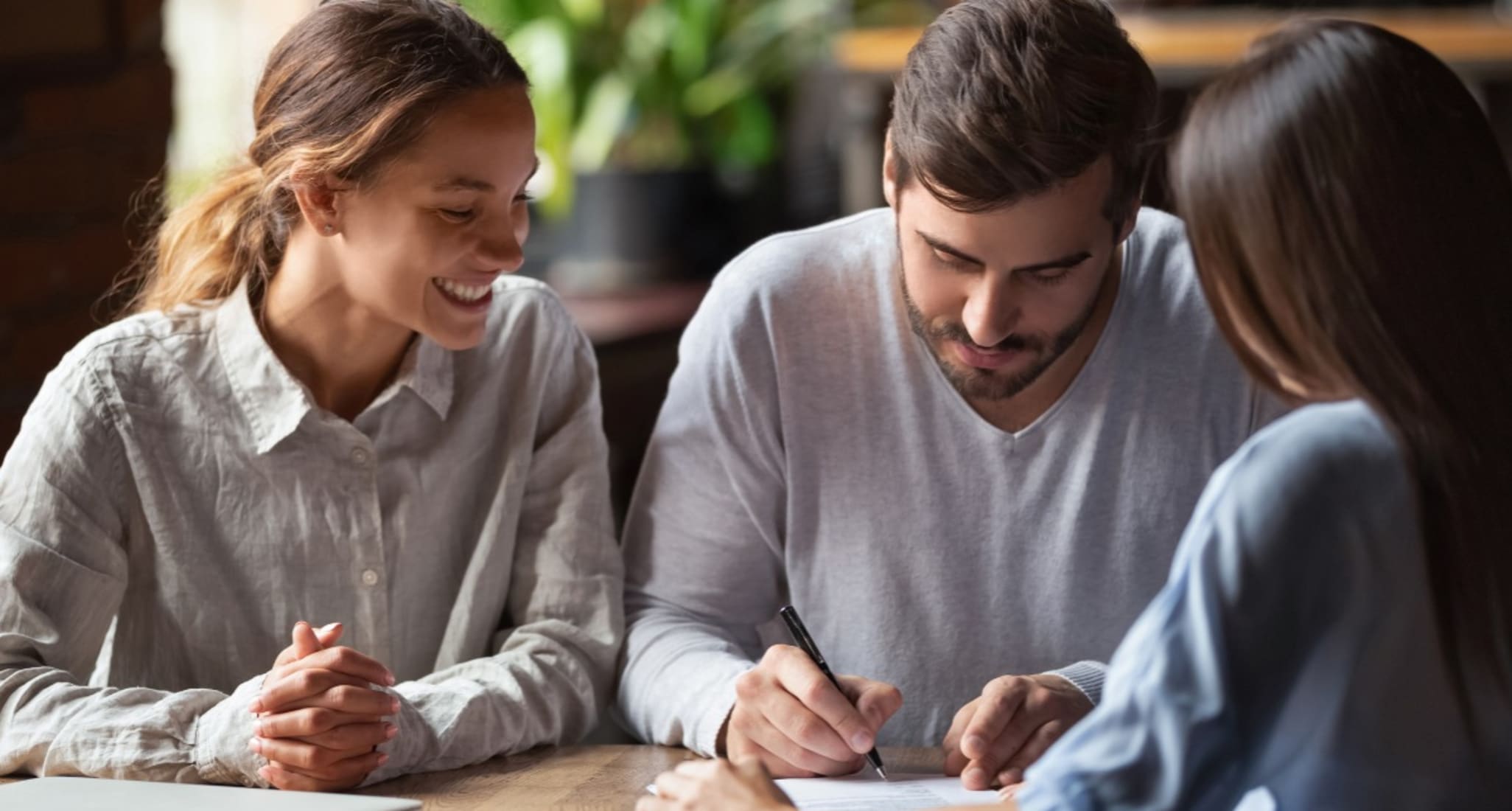 Two men study the documents they need for their mortgage.