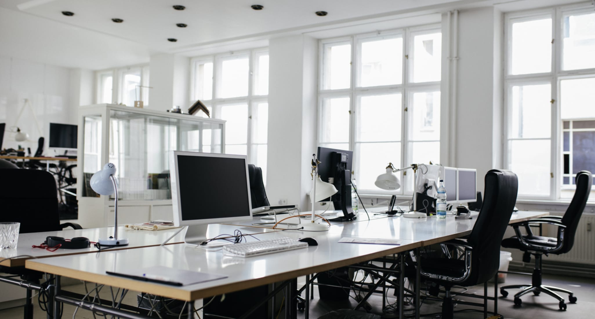 Ein Büro ist mit Schreibtischen und Computern ausgestattet.