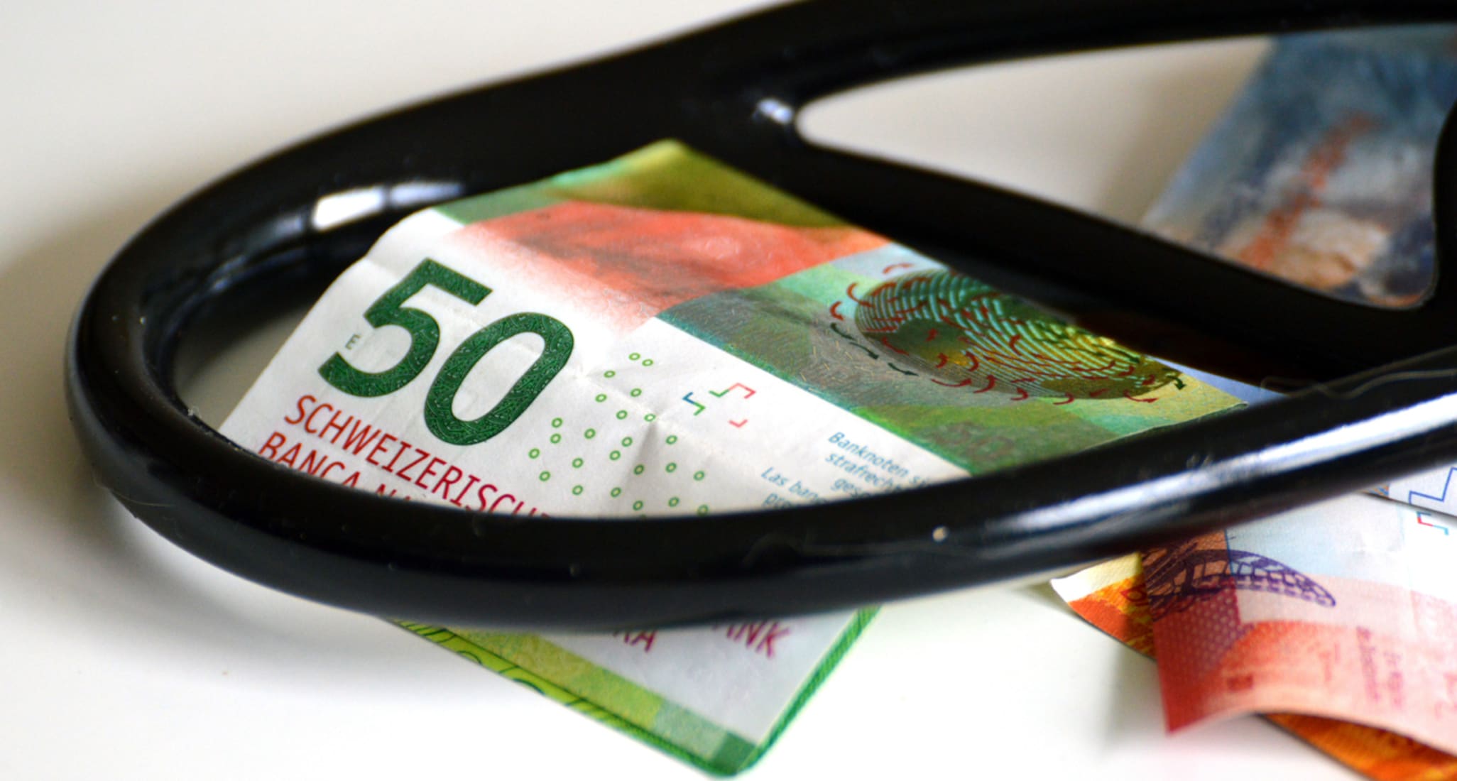 A stethoscope lies on top of various Swiss banknotes.