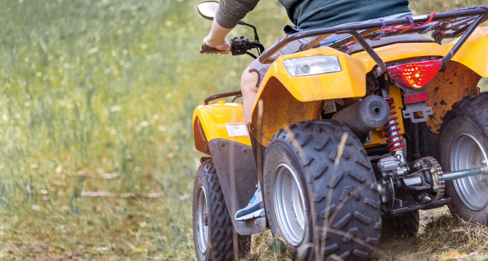 Un quad en train de rouler à travers une prairie escarpée.