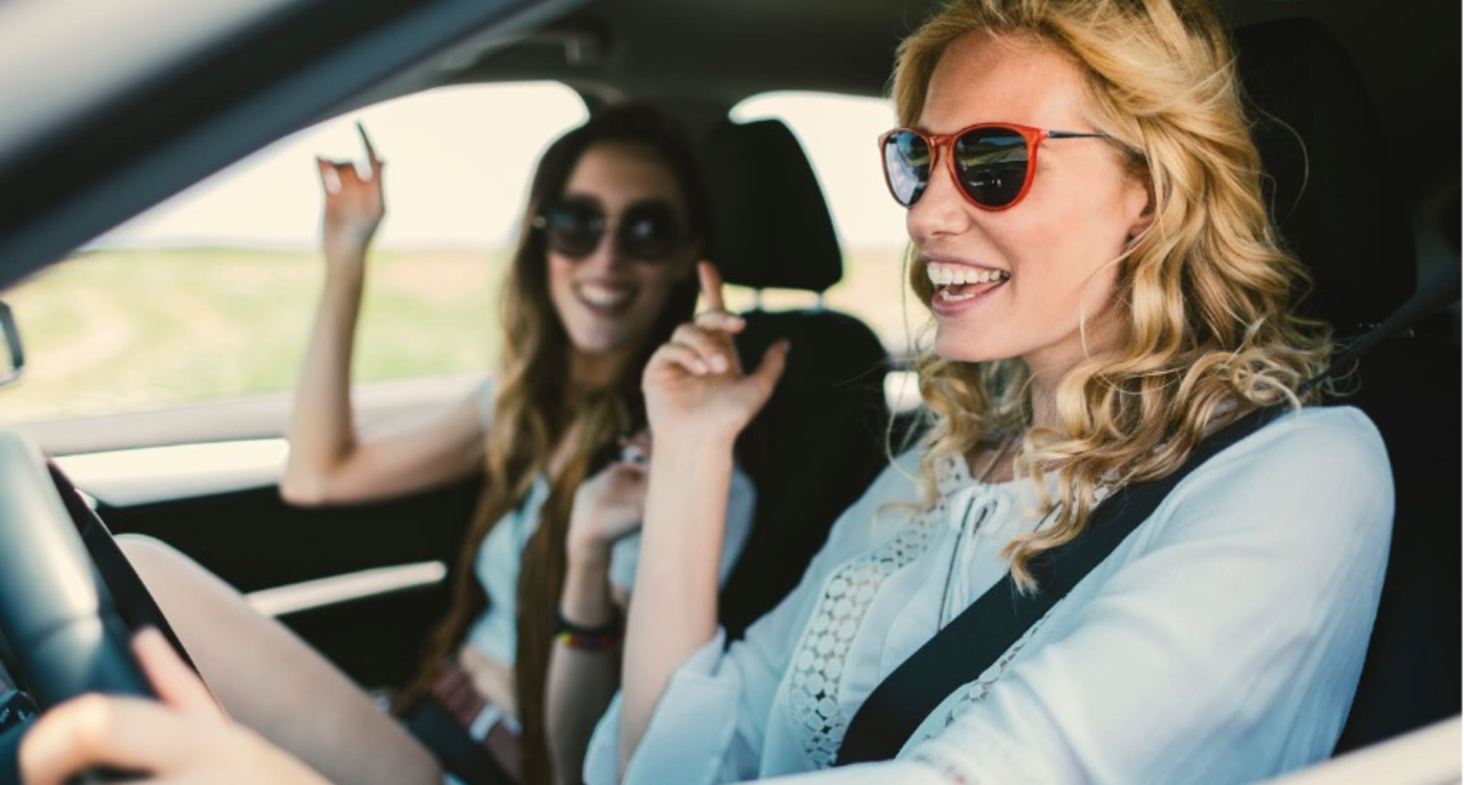 Deux filles qui font une virée en voiture et qui s'amusent.