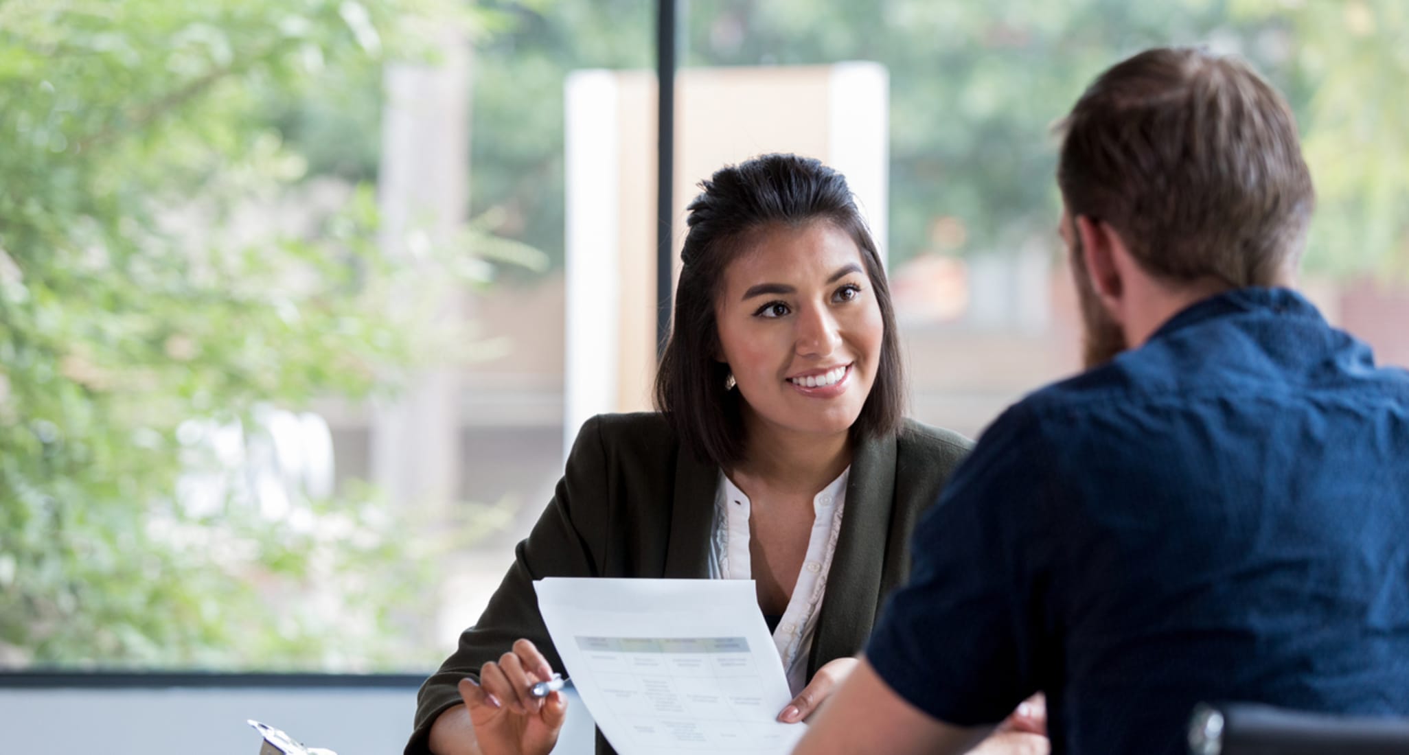 In an office, a woman helps a man with a legal matter.