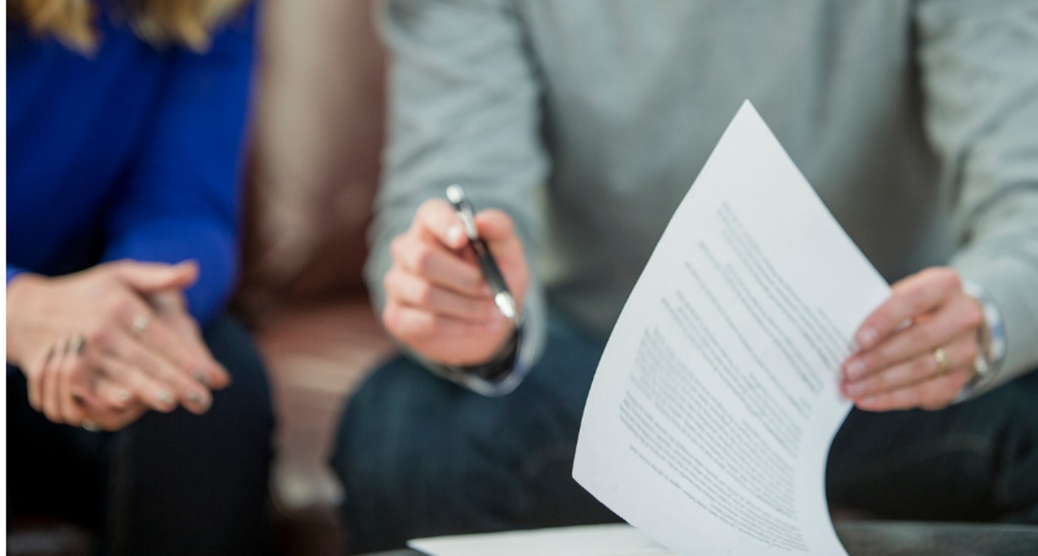 A man and a woman sign a legal protection insurance quote together. 