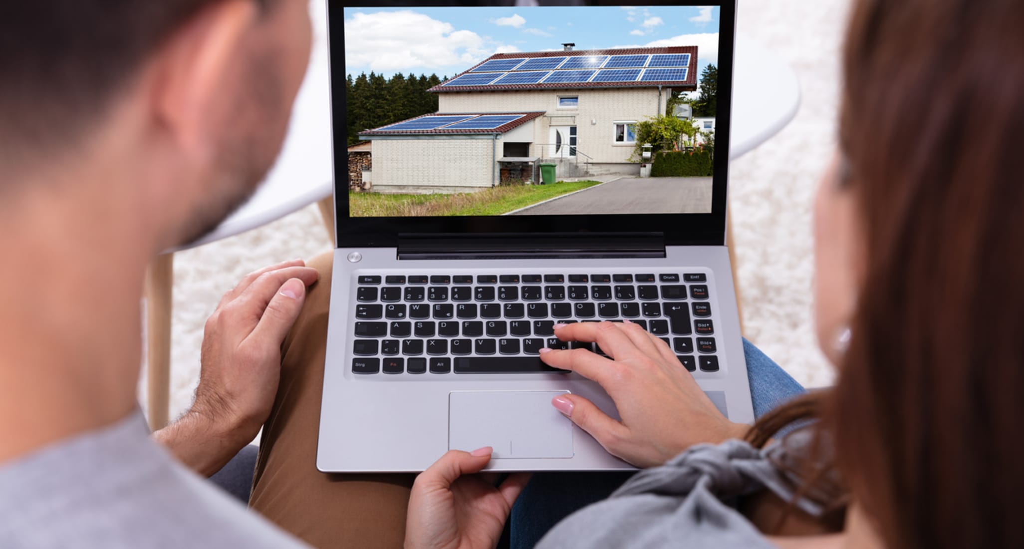 A couple looks at a property on their laptop