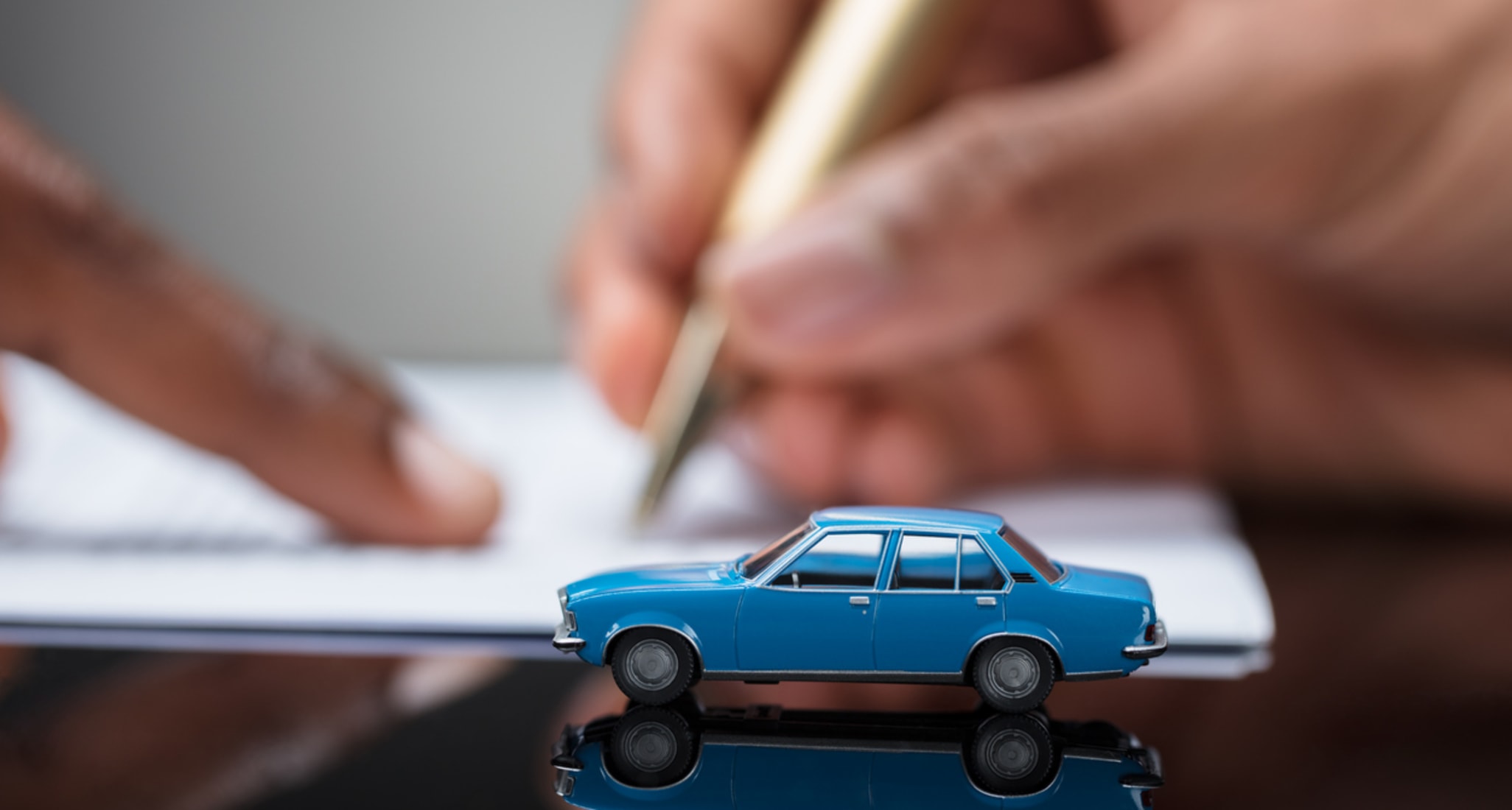 A person signing a car insurance contract.