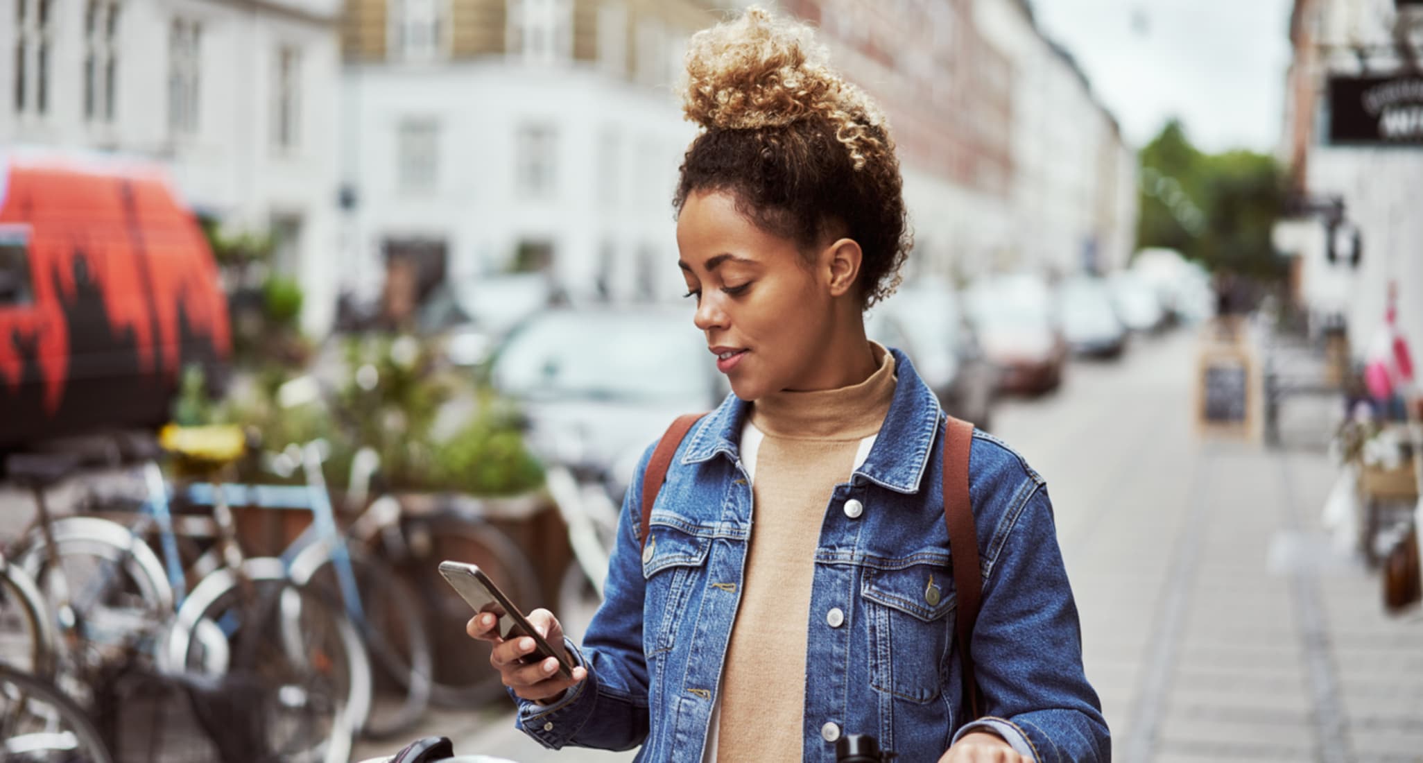 A young woman checking the area code of a phone number on her smartphone.