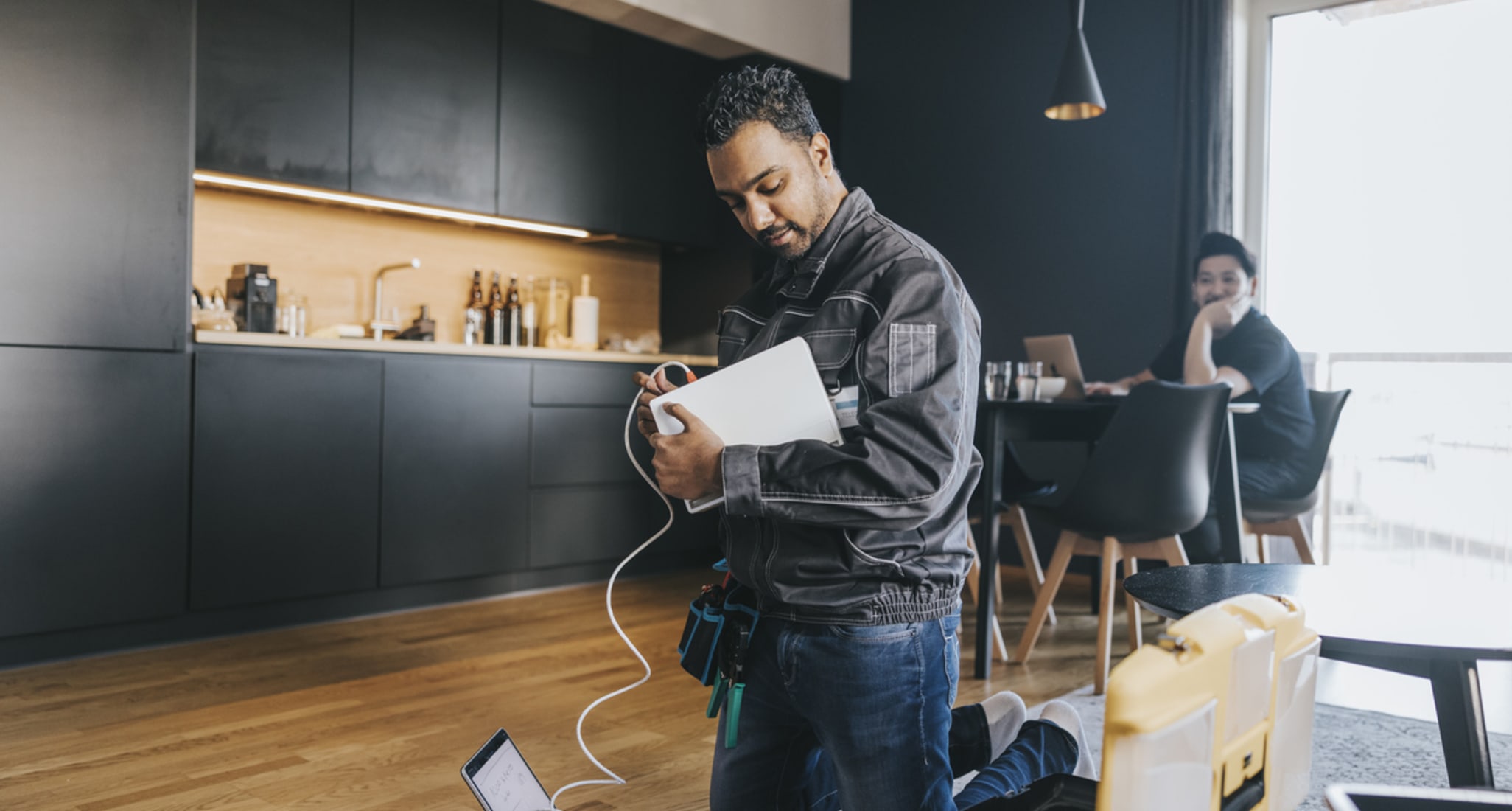 Un technicien en train d’installer un modem à fibre optique dans un appartement