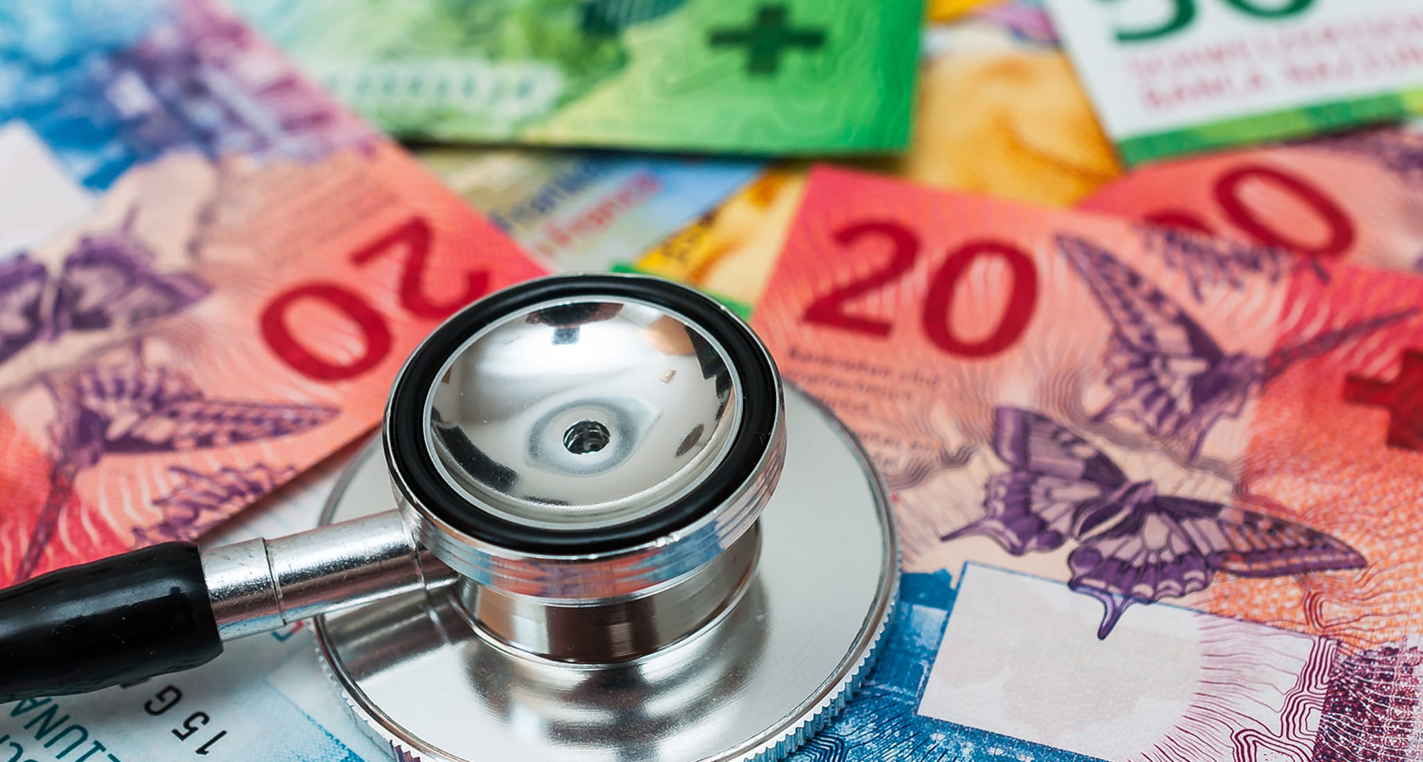 Des francs suisses et un stéthoscope sur une table en raison de la hausse des coûts de la santé