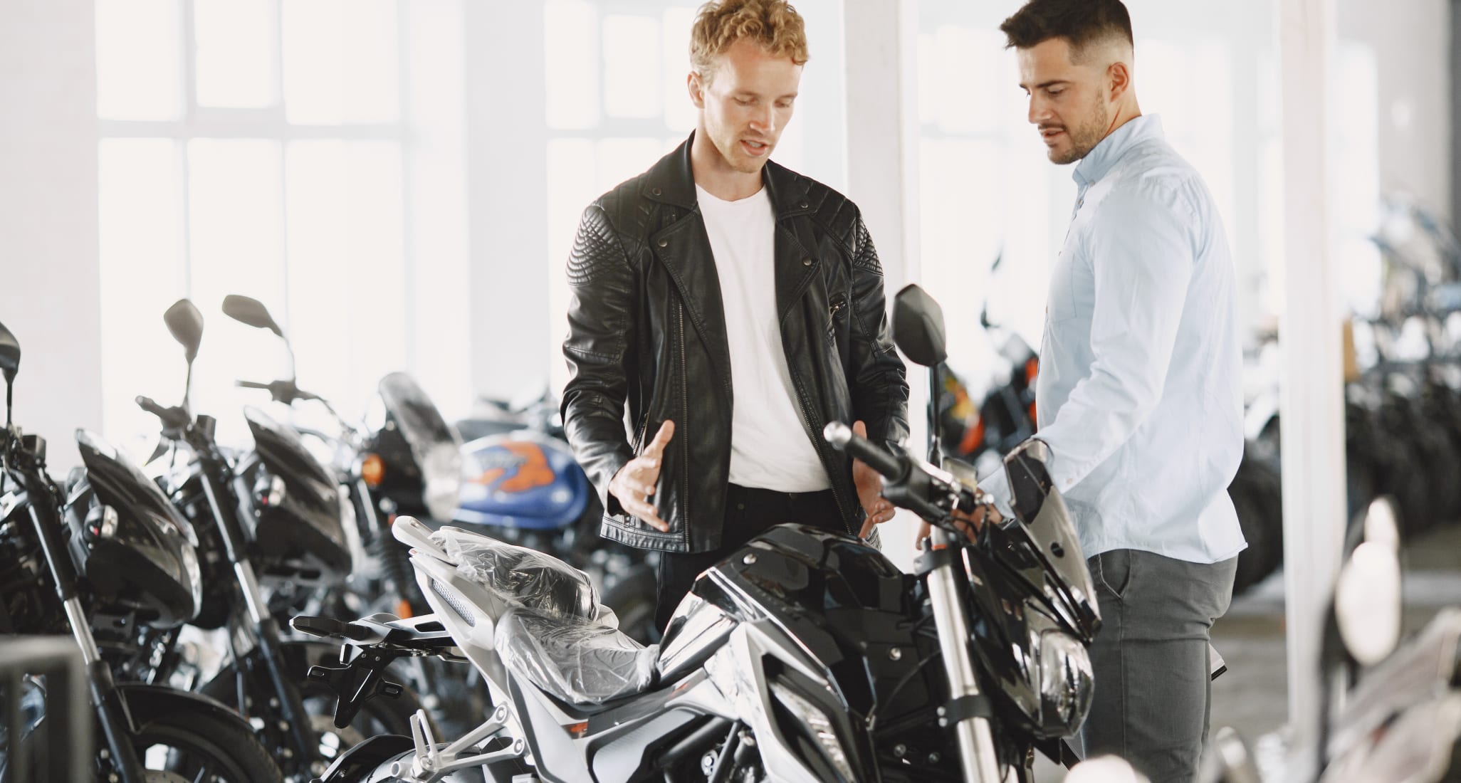 A man is being advised by another about buying a motorcycle.