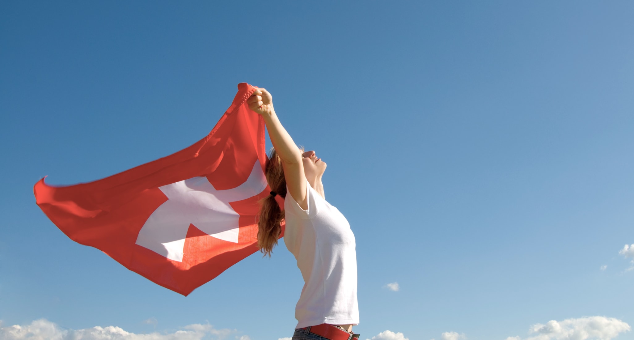 A young woman holds a Swiss flag.