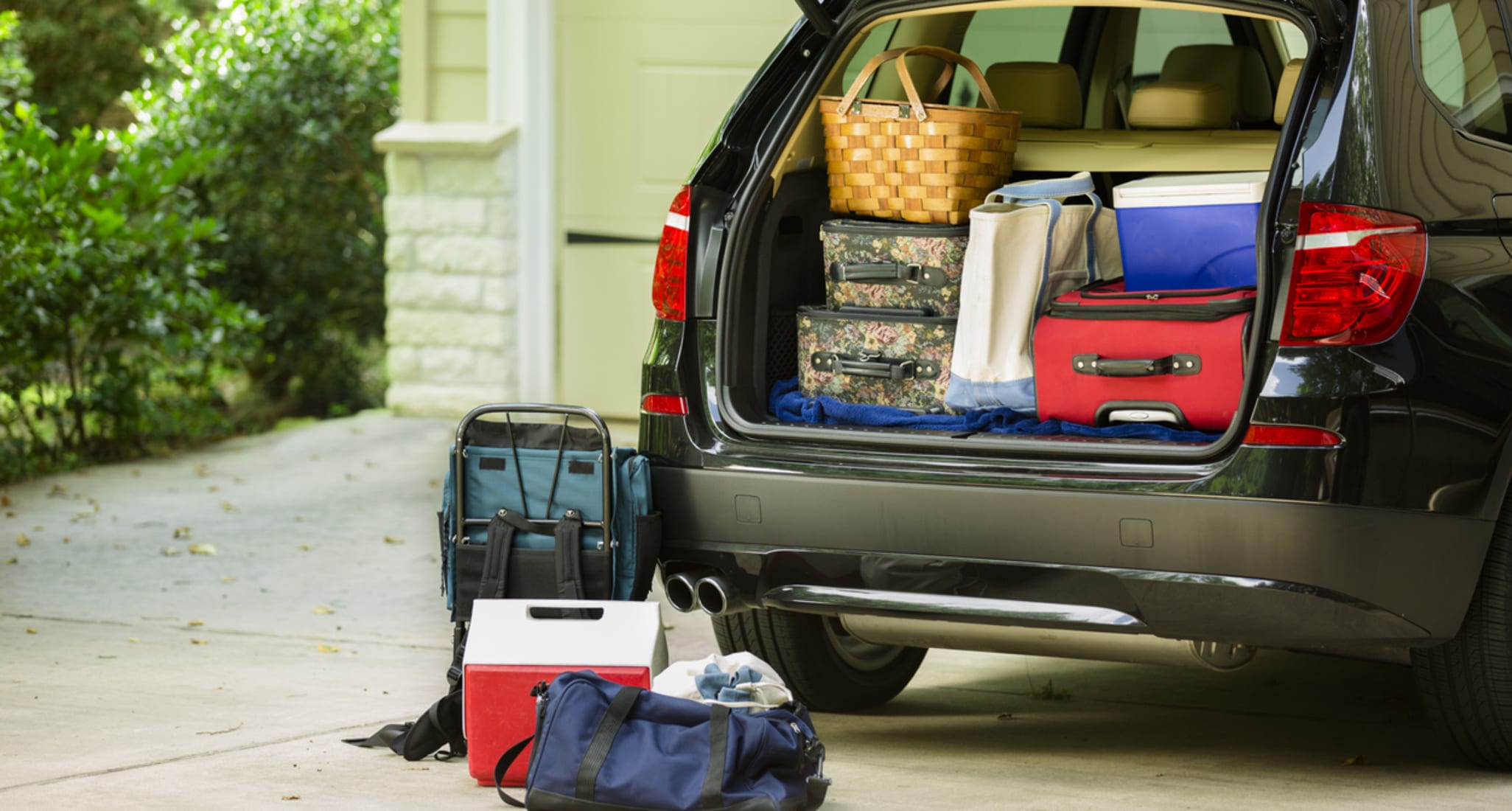 Une voiture noire, remplie de valises, prête à partir à l’étranger.