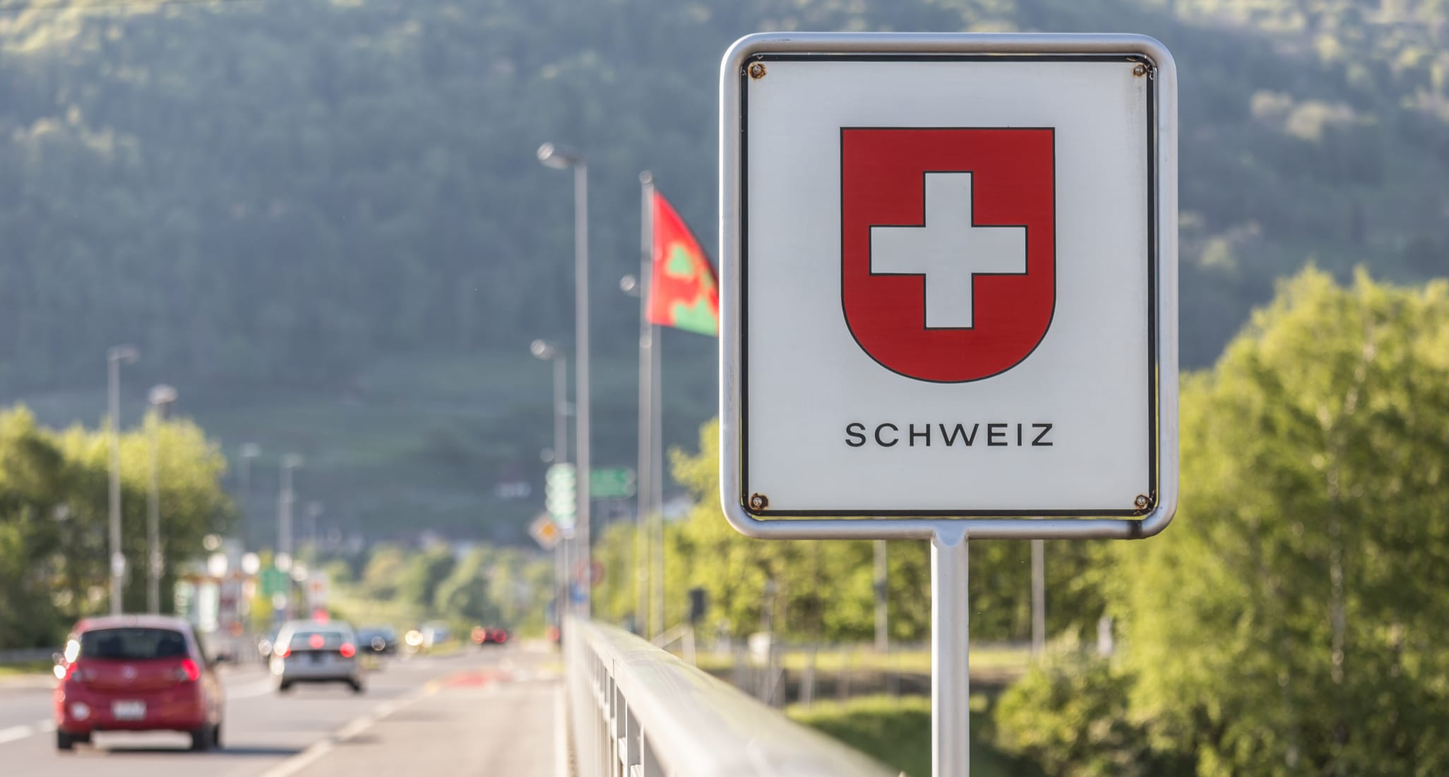 Ein Schild mit Schweizer Wappen an der Grenze zur Schweiz.