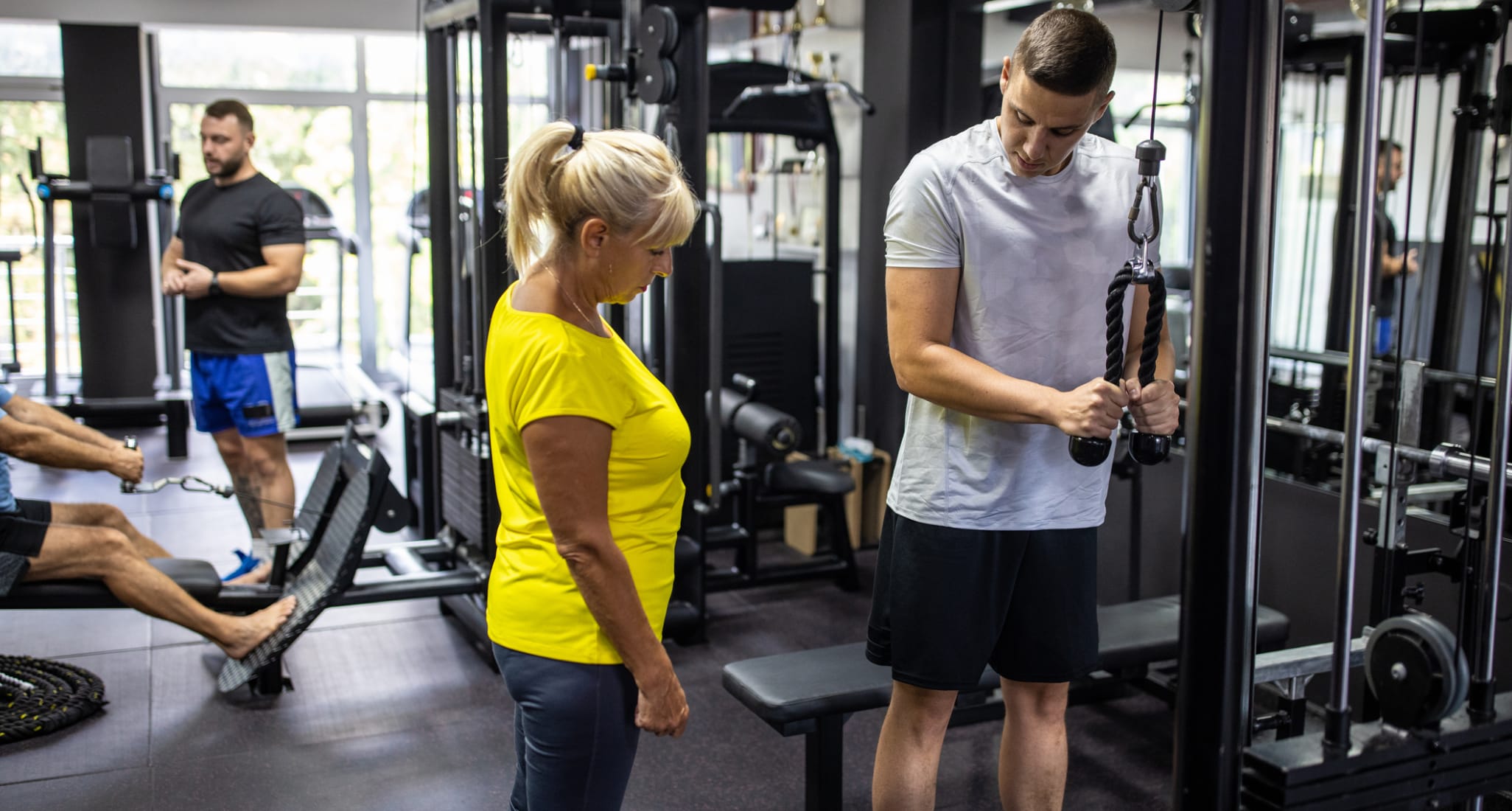 Une femme s’étire en salle de fitness.