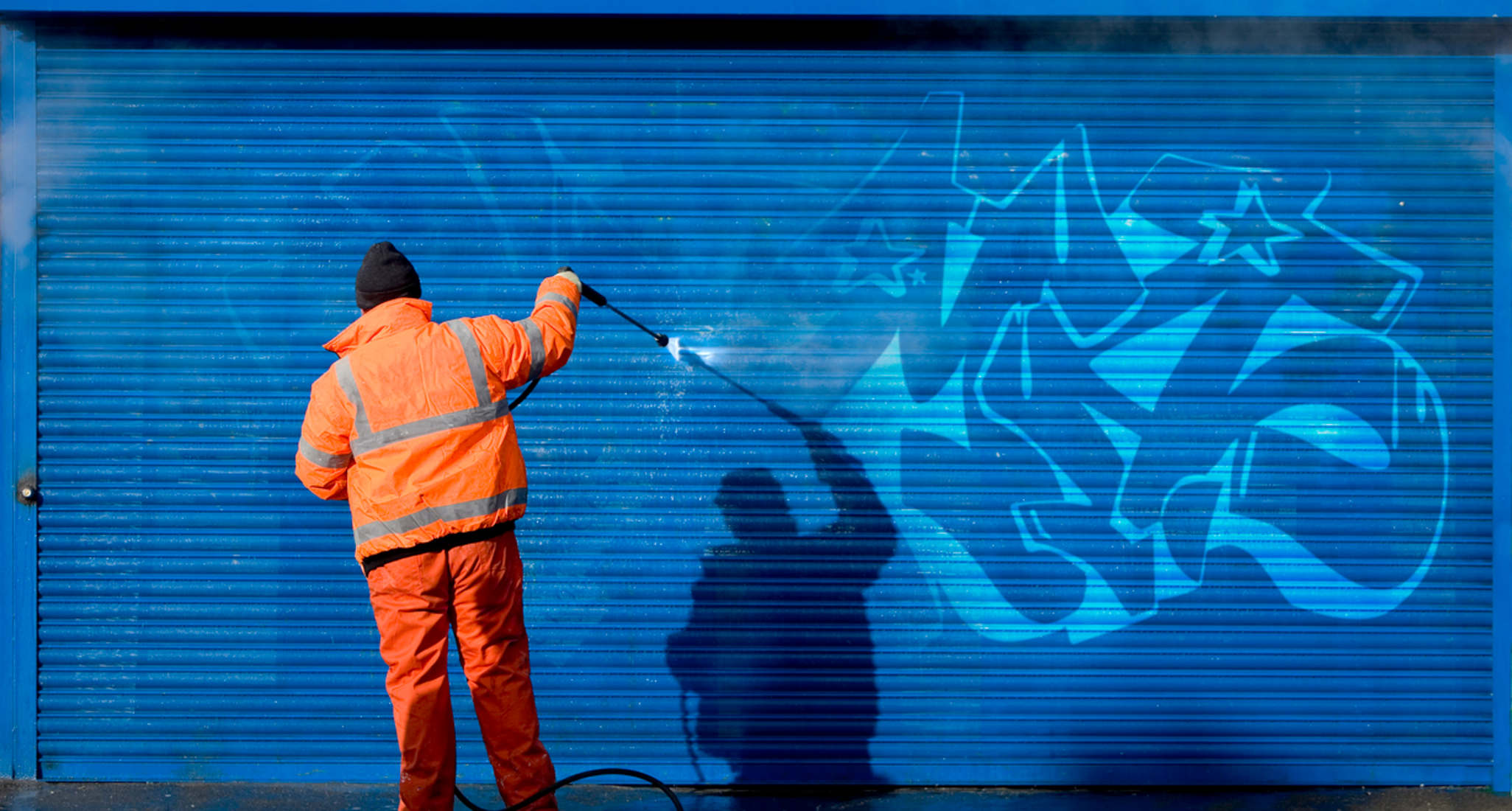 A worker removing a graffiti.