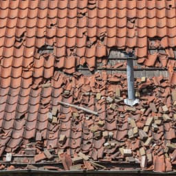 Dégâts sur un toit en tuiles provoqués par une tempête