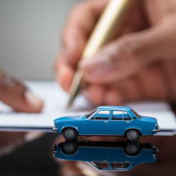 Eine Person unterzeichnet den Vertrag für die Autoversicherung.