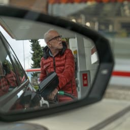 Ein älterer Herr tankt sein Auto.