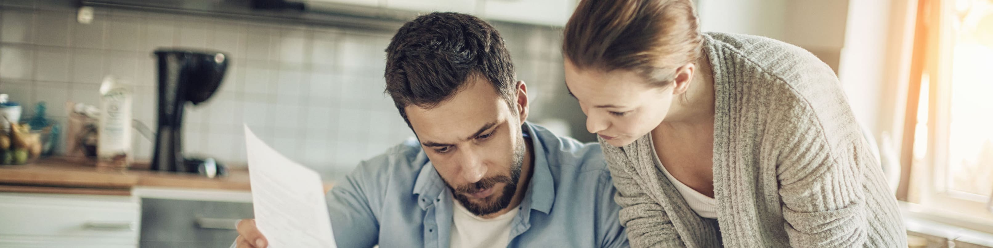 Un homme et une femme regardent avec concentration quelques documents.