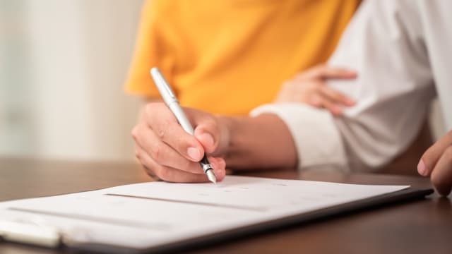 A couple signs an insurance contract.