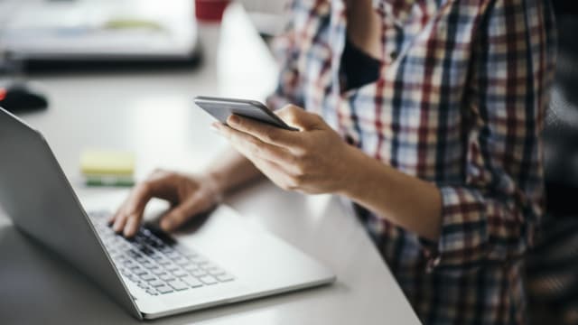 Woman with laptop looking for apartments.