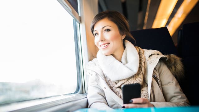 Una donna usa il cellulare in treno