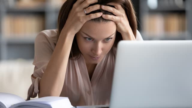 Femme assise désespérément devant son ordinateur portable