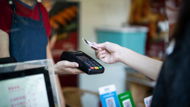 Dans un magasin, une femme paie en carte