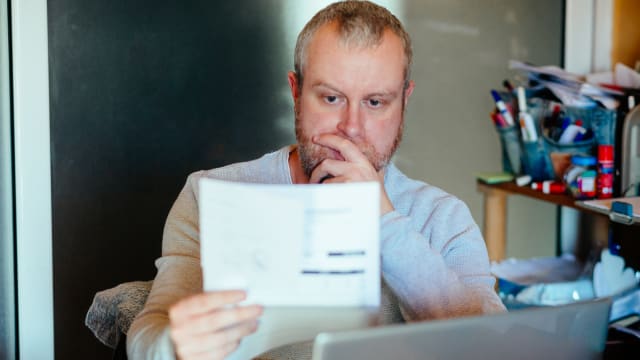 A man looking at his utility bill.