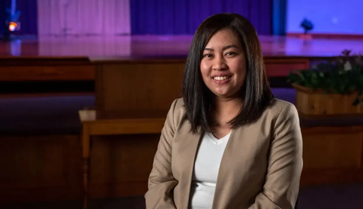 A still of Ria being interviewed in a church