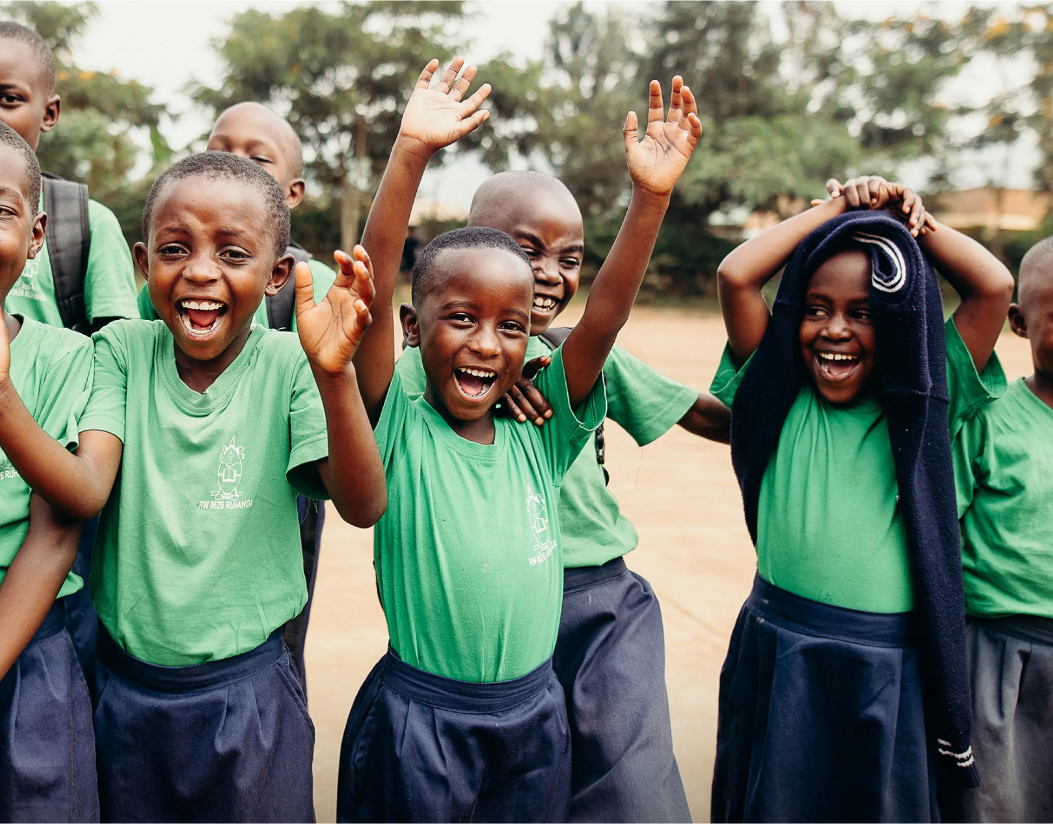 Photo of a group of students in green uniforms, smiling and laughing